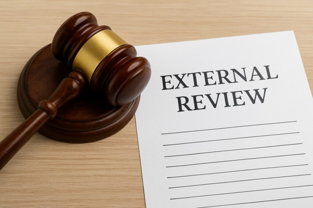 Judge's gavel resting next to official documents, representing the final step of an external review and appeal of a denied insurance claim.